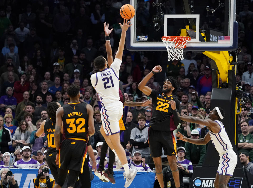 TCU forward JaKobe Coles (21) drives the lane for a basket past Arizona State forwards Alonzo Gaffney (32) and Warren Washington (22) during the second half of a first-round college basketball game in the men's NCAA Tournament on Friday, March 17, 2023, in Denver. (AP Photo/John Leyba)