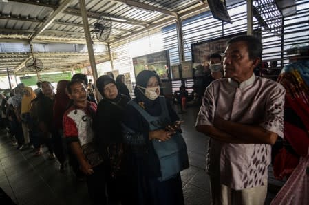 Passengers queue to refund their tickets during a major power blackout at a commuter train station in Jakarta