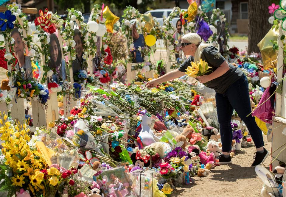 A woman places flowers at a memorial outside Uvalde's Robb Elementary School on June 2, days after a gunman killed 19 students and two teachers. A new report revealed police missteps in responding to the shooting.