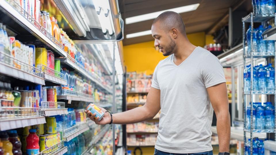 Man shopping in beverage section at supermarket.