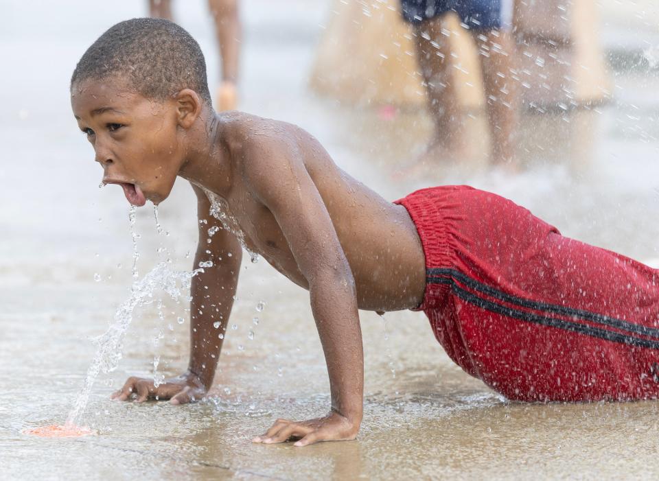 Marquel Holmes, 6, cools off Thursday, July 13, 2023, at the Crenshaw Park spray park in Canton.