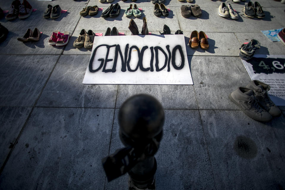A sign that says "genocide" in Spanish is displayed next to empty shoes as part of the June 1, 2018, protest outside the Capitol building in San Juan. (Bloomberg via Getty Images)