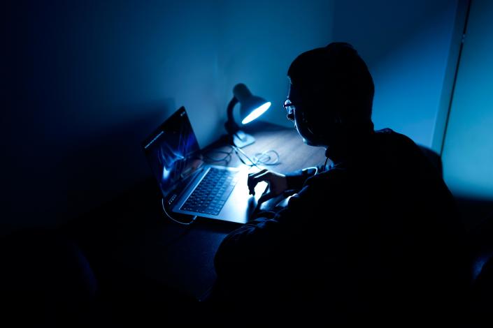 boy on computer dark room