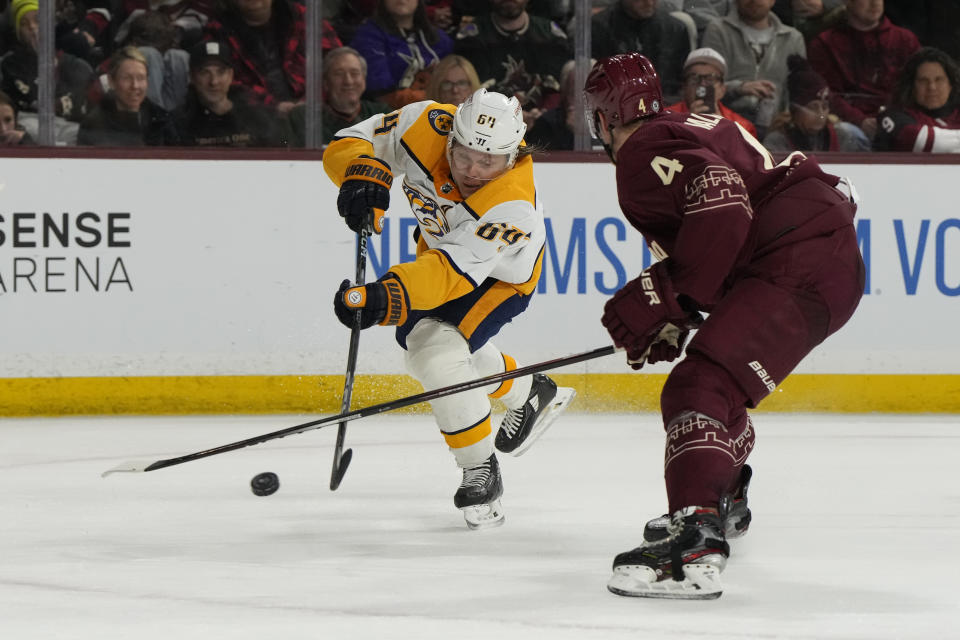 Nashville Predators center Mikael Granlund (64) shoots in front of Arizona Coyotes defenseman Juuso Valimaki in the second period during an NHL hockey game, Sunday, Feb. 26, 2023, in Tempe, Ariz. (AP Photo/Rick Scuteri)