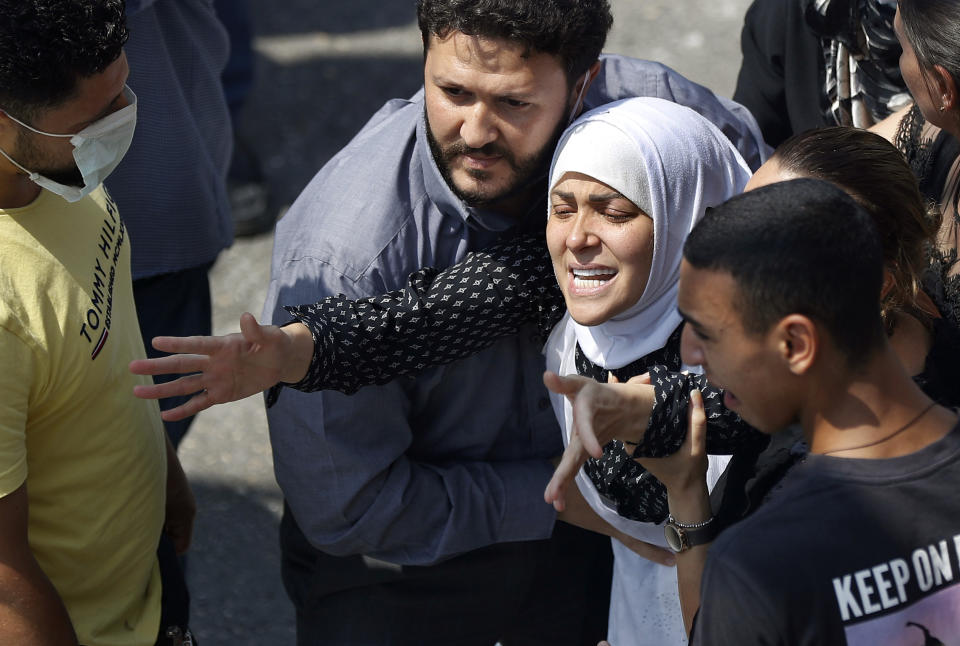 The wife of Rami Kaaki, one of ten firefighters who were killed during the last week's explosion that hit the seaport of Beirut, tries to reach her husband's coffin during his funeral, at the firefighter headquarters in Beirut, Lebanon, Tuesday, Aug. 11, 2020. (AP Photo/Hussein Malla)