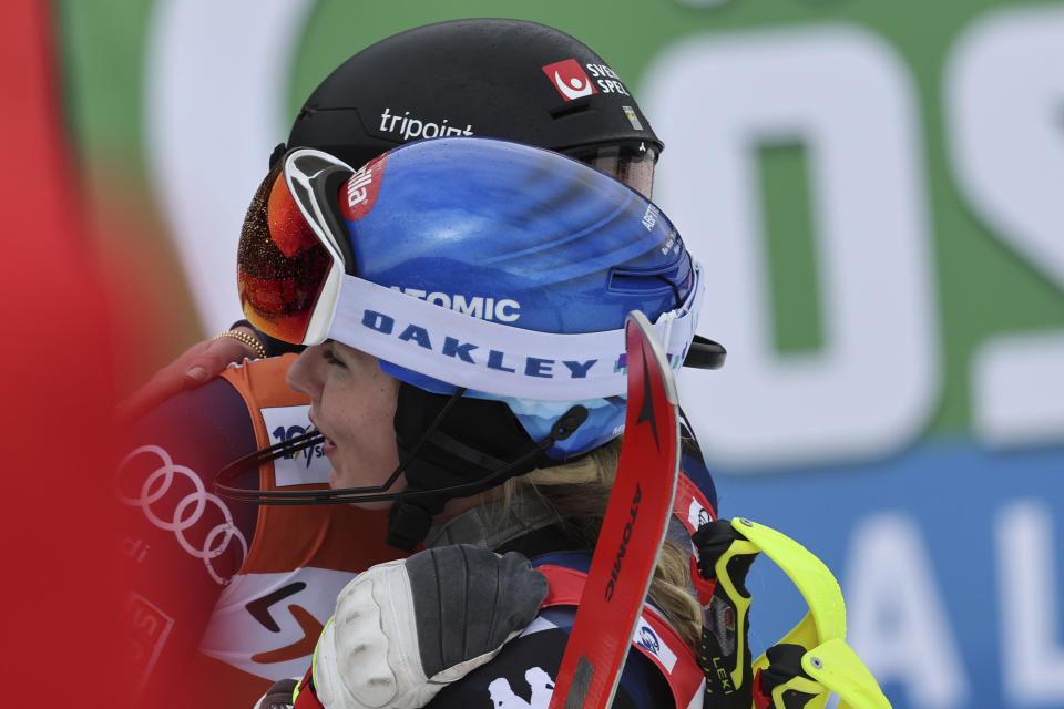 United States' Mikaela Shiffrin, foreground, winner of an alpine ski, women's World Cup slalom race, hugs second-placed Sweden's Anna Swenn Larsson, in Saalbach, Austria, Saturday, March 16, 2024. (AP Photo/Marco Trovati)