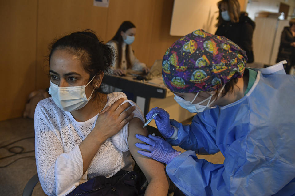 FILE - In this March 24, 2021 file photo, a woman receives a dose of the AstraZeneca COVID-19 vaccine, during a mass vaccination campaign at San Pedro Hospital, in Logrono, northern Spain. While some non-European Union nations were speeding ahead with emergency use authorizations for vaccines, the EU's drug regulator moved more slowly — and hasn't caught up. (AP Photo/Alvaro Barrientos, File)