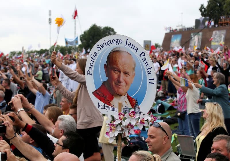 FILE PHOTO: A faithful holds a picture of John Paul II as they greet Pope Francis as he arrives at the Jasna Gora shrine in Czestochowa