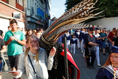 "The Savage", a white performer in a blackface disguise, kisses a girl during the festival Ducasse d'Ath in Ath