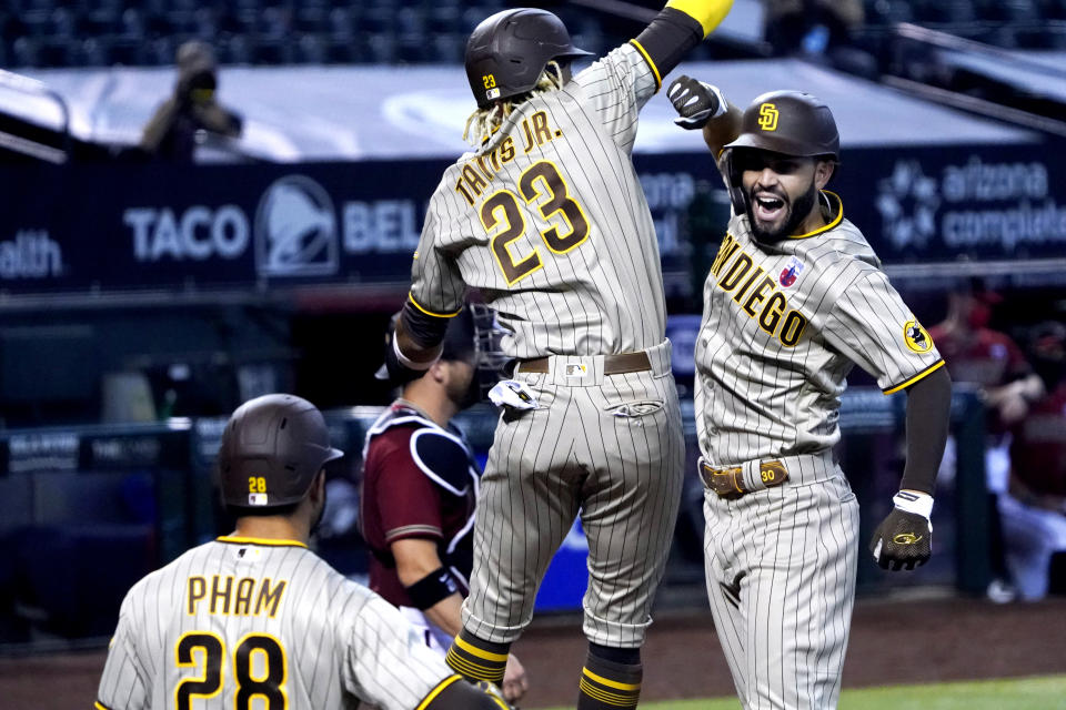 San Diego Padres' Eric Hosmer celebrates with Fernando Tatis Jr. (23) and Tommy Pham (28) after hitting a two-run home run against the Arizona Diamondbacks in the sixth inning during a baseball game, Sunday, Aug 16, 2020, in Phoenix. (AP Photo/Rick Scuteri)