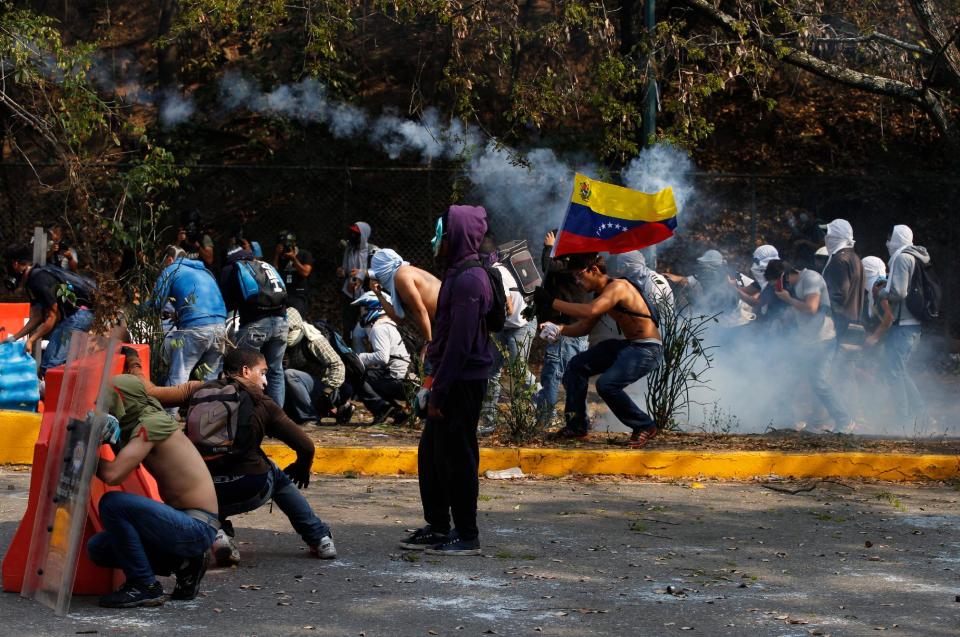 Manifestantes hacen frente a agentes antimontines en una protesta antigubernamental en Caracas, Venezuela, el miércoles 12 de marzo de 2014. (AP Photo/Fernando Llano)