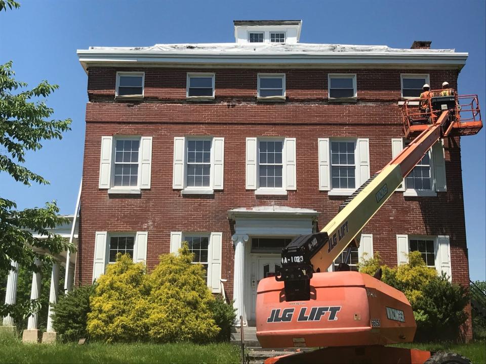 Workers remove marble trim and a date stone Tuesday from the Ephraim Tomlinson Mansion in Stratford. The historic building will be demolished after removal of some exterior artifacts so 191 units of senior housing can be built.