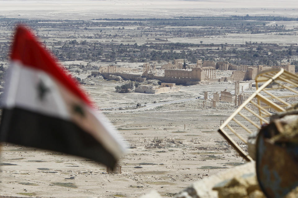 FILE PHOTO A Syrian national flag flutters as the ruins of the historic city of Palmyra are seen in the background, in Homs Governorate, Syria April 1, 2016. REUTERS/Omar Sanadiki/File Photo