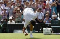 Novak Djokovic of Serbia pats the grass after winning his match against Jarkko Nieminen of Finland at the Wimbledon Tennis Championships in London, July 1, 2015. REUTERS/Toby Melville