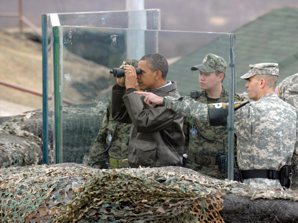 FILE - In this March 25, 2012, file photo, then U.S. President Barack Obama, second left, looks through binoculars to see North Korea from Observation Post Ouellette in the Demilitarized Zone, the tense military border between the two Koreas, in Panmunjom, South Korea. President Donald Trump is inviting North Korea's Kim Jong Un to shake hands during a visit to the demilitarized zone with South Korea. Trump is scheduled to visit South Korea later Saturday after meetings at the Group of 20 summit in Osaka, Japan. (AP Photo/Susan Walsh, File)