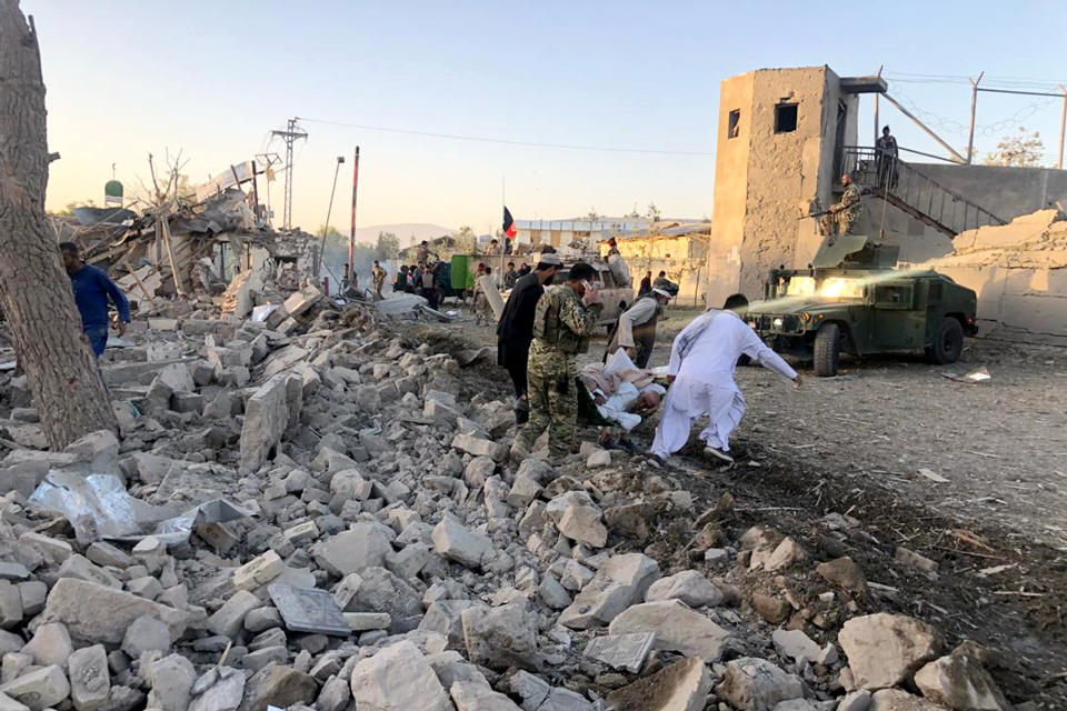 Afghan security members and people work at the site of a suicide attack in Zabul, Afghanistan, Thursday, Sept. 19, 2019. A powerful early morning suicide truck bomb devastated a hospital in southern Afghanistan on Thursday. (AP Photo/Ahmad Wali Sarhadi)