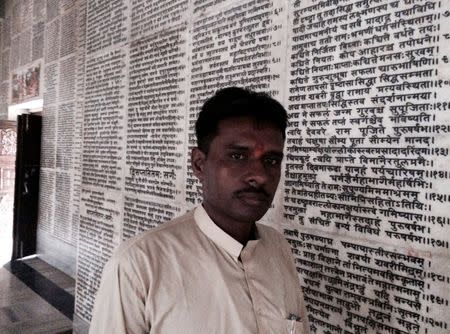 Sharad Sharma, a spokesman of Hindu nationalist group Vishva Hindu Parishad (VHP), walks past a wall with inscription of Hindu religious book Ramayana, in a temple in Ayodhya in the northern state of Uttar Pradesh, India, June 16, 2016. REUTERS/Rupam Jain