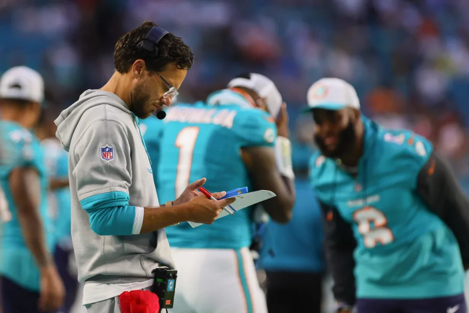 Aug 17, 2024; Miami Gardens, Florida, USA; Miami Dolphins head coach Mike McDaniel looks at a screen on the sideline against the Washington Commanders during the second quarter of a preseason game at Hard Rock Stadium. Mandatory Credit: Sam Navarro-USA TODAY Sports