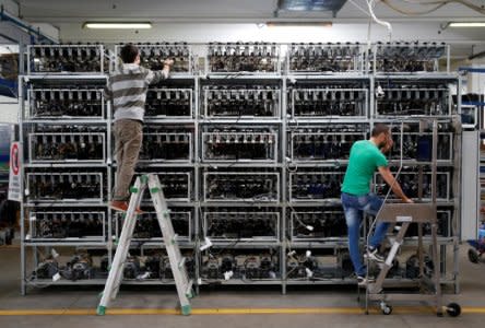 FILE PHOTO: Employees work on bitcoin mining computers at Bitminer Factory in Florence, Italy, April 6, 2018. REUTERS/Alessandro Bianchi/File Photo