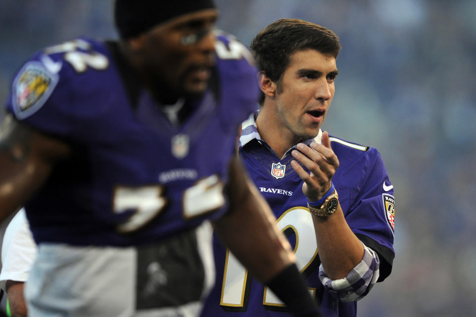 Linebacker Ray Lewis #52 of the Baltimore Ravens runs on the field alongside Olympic swimmer Michael Phelps before the Ravens take on the Cincinnati Bengals at M&T Bank Stadium on September 10, 2012 in Baltimore, Maryland. (Photo by Patrick Smith/Getty Images)