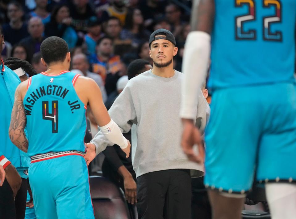 Jan 8, 2023; Phoenix, Ariz., U.S.;  Phoenix Suns guard Devin Booker slaps hands with teammates during the first quarter against the Cleveland Cavaliers at Footprint Center.