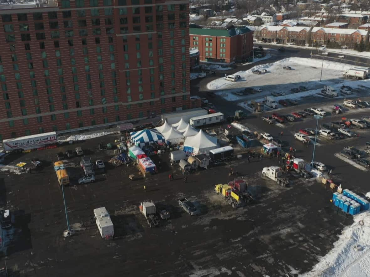 A photo taken by a drone on Monday shows an overview of a logistics camp set up by protesters in an Ottawa parking lot on Coventry Road between the RCGT baseball stadium and the Courtyard by Marriott hotel. Experts say the co-ordination of protesters shows they may have military, police or survivalist training.   (Eric Laporte/Ottawa Drones - image credit)