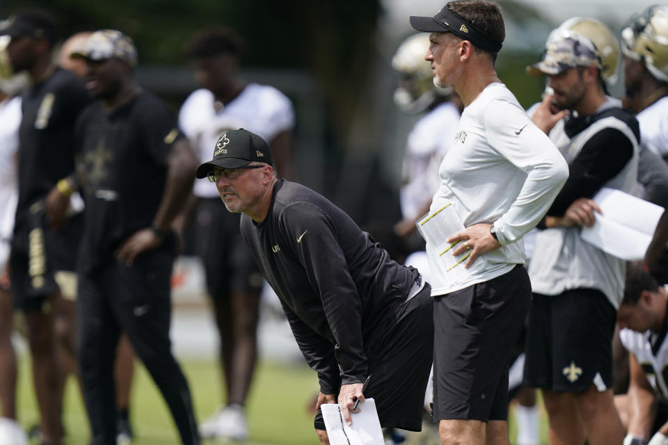FILE - New Orleans Saints offensive coordinator Pete Carmichael and head coach Dennis Allen, right, watch during training camp at their NFL football training facility in Metairie, La., Thursday, July 28, 2022. For all but one year since 2006, recently retired Saints coach Sean Payton has overseen the offensive game plan and has usually called plays on game days. This weekend in Atlanta, the Saints debut an offense now run exclusively by long-time Payton understudy Pete Carmichael Jr. (AP Photo/Gerald Herbert, File)