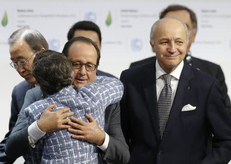 French President Francois Hollande (C) embraces Christiana Figueres, Executive Secretary of the UN Framework Convention as French Foreign Affairs Minister Laurent Fabius, President-designate of COP21, looks on at the final plenary session at the World Climate Change Conference 2015 (COP21) at Le Bourget, near Paris, France, December 12, 2015. REUTERS/Stephane Mahe