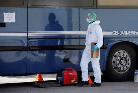 A French investigator walks past a Gendarmerie mobile forensic van in Seynes-les-Alpes near the crash site of a Germanwings Airbus A320 in French Alps March 27, 2015. REUTERS/Eric Gaillard