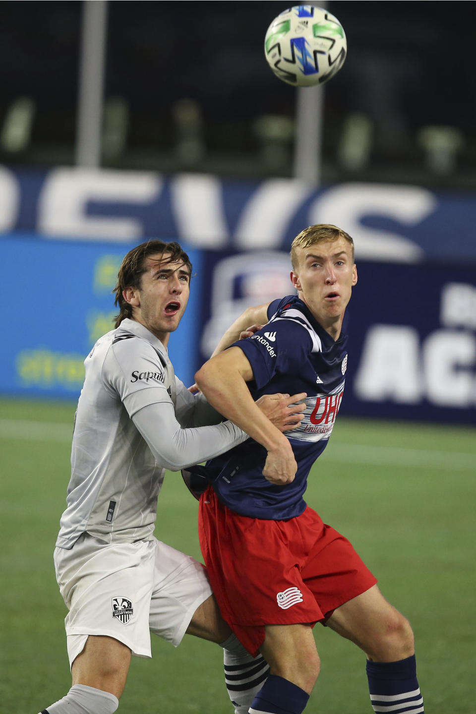 Montreal Impact defender Luis Binks, left, and New England Revolution forward Adam Buksa watch the ball during the first half of an MLS soccer matc Friday, Nov. 20, 2020, in Foxborough, Mass. (AP Photo/Stew Milne)