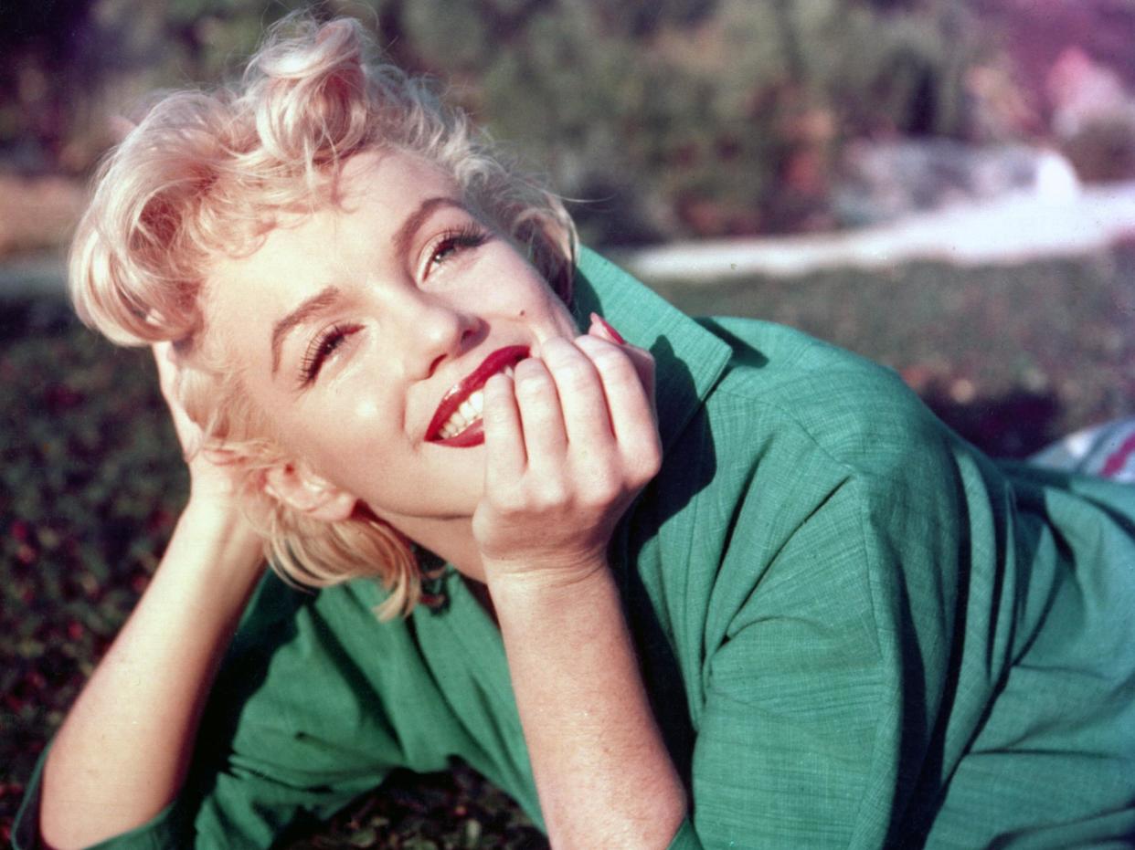 Marilyn Monroe poses for a portrait laying on the grass in 1954 in Palm Springs, California: Photo by Baron/Getty Images