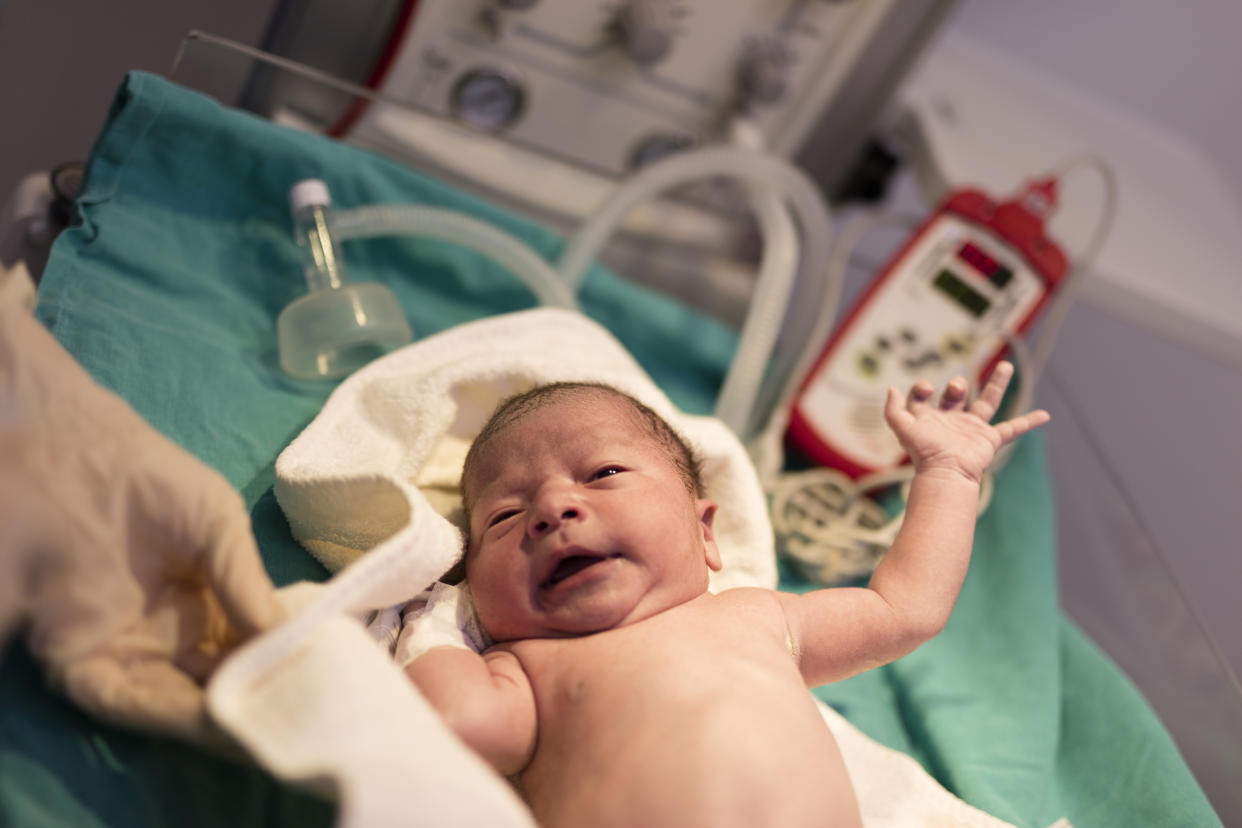 A newborn in a hospital awaits his circumcision. 