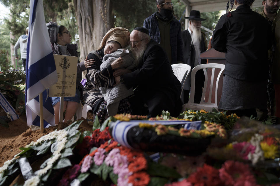 The wife, center, of the Israeli staff sergeant Elisha Yehonatan Lober, who was killed in battle in the Gaza Strip, mourns during the funeral of her husband at the Mount Herzl military cemetery in Jerusalem, Israel, Wednesday, Dec. 27, 2023. (AP Photo/Leo Correa)