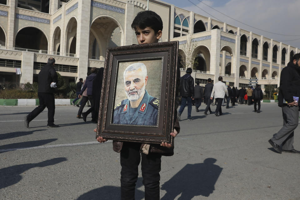 A boy carries a portrait of Iranian Revolutionary Guard Gen. Qassem Soleimani, who was killed in the U.S. airstrike in Iraq, prior to the Friday prayers in Tehran, Iran, Jan. 3, 2020. Iran has vowed 