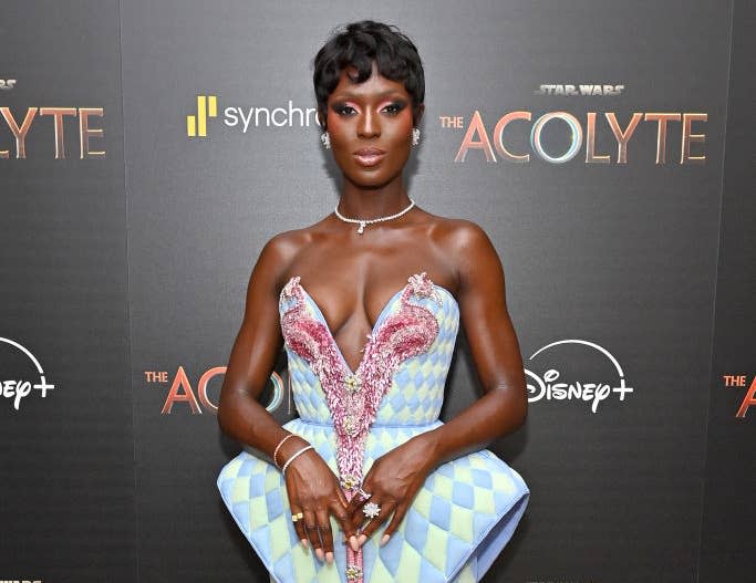 Jodie Turner-Smith  in a futuristic, structured mini dress poses on the red carpet at a media event