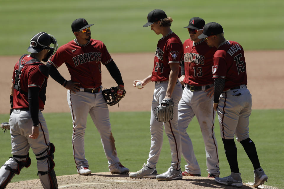 Arizona Diamondbacks starting pitcher Luke Weaver, middle, meets players on the mound before leaving during the fourth inning of the team's baseball game against the San Diego Padres, Monday, July 27, 2020, in San Diego. (AP Photo/Gregory Bull)