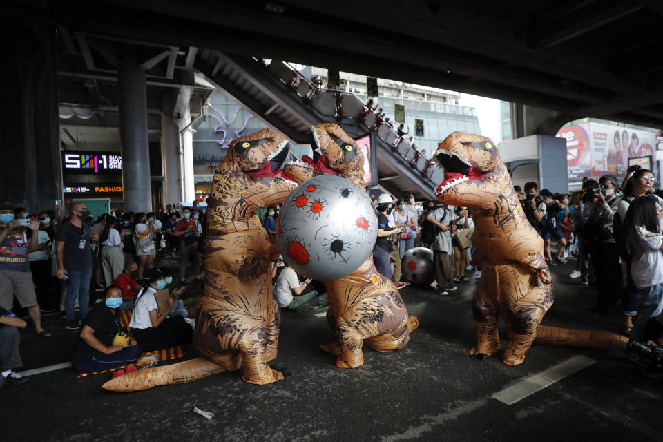 Dinosaur mascots hold a large ball depicting an asteroid during a student rally in Bangkok, Saturday, Nov. 21, 2020. Organized by a group that mockingly calls themselves "Bad Students," the rally calls for educational reforms and also supports the broader pro-democracy movement's demands for constitutional change. (AP Photo/Sakchai Lalit)