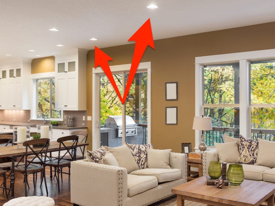 Living room with overhead pot lights and red arrows pointing to them