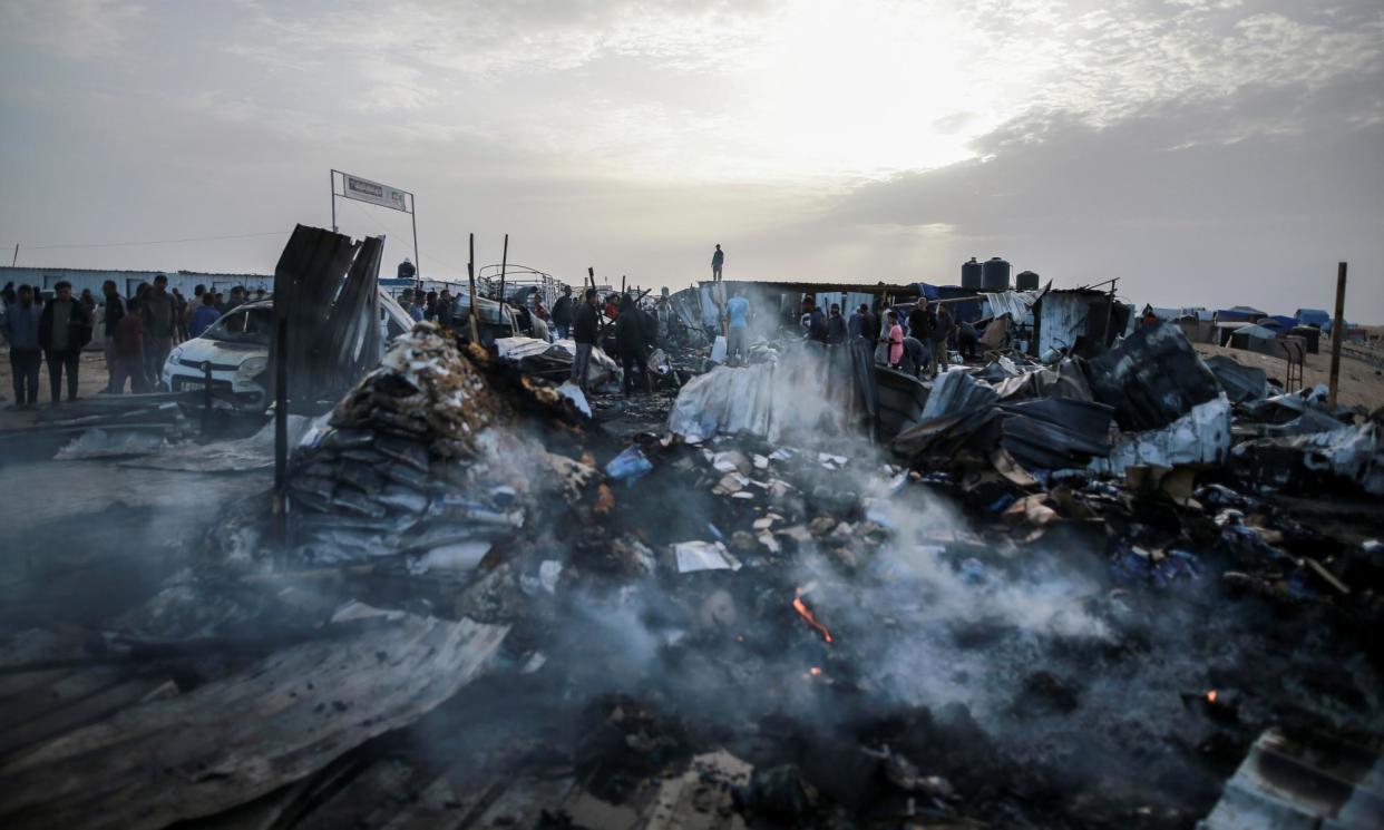 <span>Palestinians look at the destruction after an Israeli airstrike where displaced people were staying in Rafah, Gaza, on 27 May. Palestinian health workers said Israeli airstrikes <a href="https://www.theguardian.com/us-news/article/2024/may/27/first-thing-deadly-israeli-airstrike-on-refugee-tents-in-rafa-leaves-aid-groups-horrified" rel="nofollow noopener" target="_blank" data-ylk="slk:killed at least 35 people;elm:context_link;itc:0;sec:content-canvas" class="link rapid-noclick-resp">killed at least 35 people</a> in the area. Israel's army confirmed the airstrike and said it hit a Hamas installation and killed two senior Hamas militants.</span><span>Photograph: Jehad Alshrafi/AP</span>