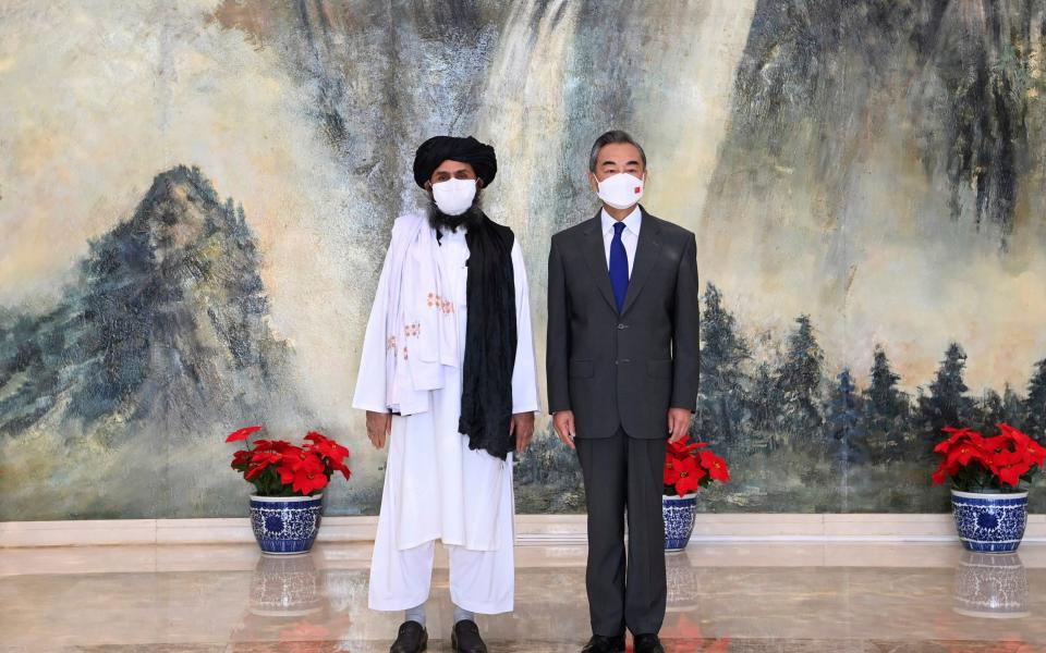 Taliban co-founder Mullah Abdul Ghani Baradar, left, and Chinese Foreign Minister Wang Yi posing for a photo during a meeting in China in July - Li Ran /AP