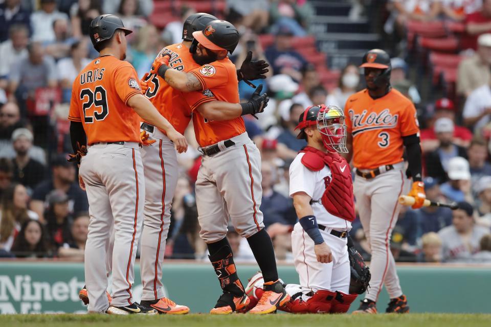 Baltimore Orioles' Rougned Odor, third from left, celebrates his three-run home run that also drove in Anthony Santander (25) and Ramon Urias (29), as Boston Red Sox's Christian Vazquez, second from right, kneels at home plate during the third inning of the second game of a baseball doubleheader, Saturday, May 28, 2022, in Boston. (AP Photo/Michael Dwyer)