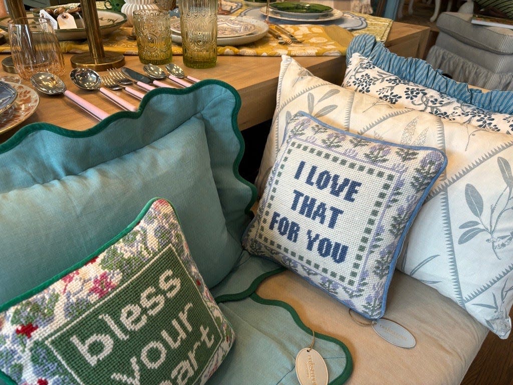 Pillows with messages, "I love that for you," and "Bless your heart," sit on a displayed couch in Oakstreet Shoppe April 19.