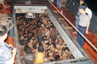 Police speak to would-be migrants below deck on a fishing boat off the western coast of Rakhine state, northern Myanmar on May 22, 2015