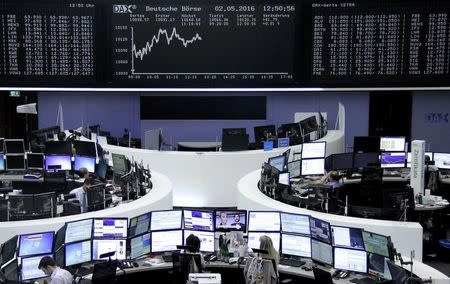 Traders work at their desks in front of the German share price index, DAX board, at the stock exchange in Frankfurt, Germany, May 2, 2016. REUTERS/Staff/Remote