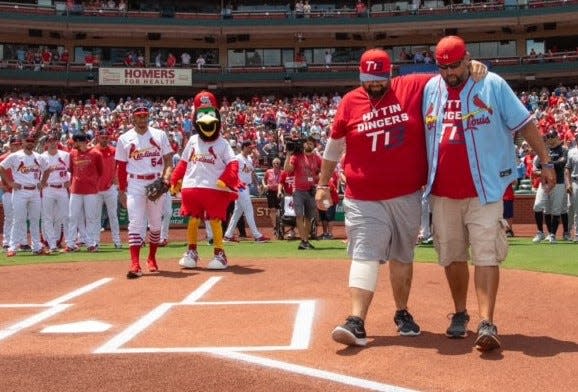 Terry Badger II (left) walks out with his brother Tony Badger to throw the ceremonial first pitch at the Cardinals-Yankees game Sunday July 2, 2023.