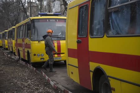 A man walks between emergency vehicles parked outside Zasyadko coal mine in Donetsk March 4, 2015.REUTERS/Baz Ratner