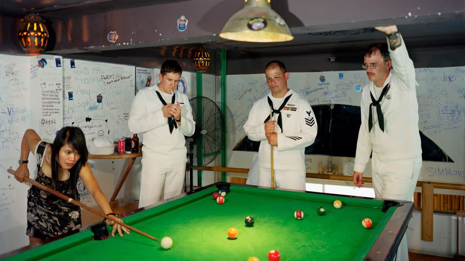 Sailors from the USS Preble play pool with a woman in a bar in Da Nang, Vietnam; a photo from Lê's "Events Ashore" series. - Courtesy the artist/Marian Goodman Gallery