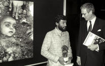 Indian photographer Pablo Bartholomew (L) poses with Dutch Foreign Minister Hans Van Den Broek in Amsterdam, April 14, 1985, after receiving an award for Best World Press Photo of 1984. Behind them is the winning entry, which shows a child victim in his native India of the Bhopal disaster, caused by a gas leak from the Union Carbide pesticide plant. Photo: Scanned from negative Reuters/E. Werner CMC