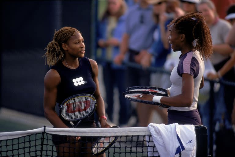 Serena Williams habla con su hermana Venus después de que ella se retira del torneo durante la Tennis Masters Series en el Indian Wells Garden en Indian Wells, California, el 15 de marzo de 2001.