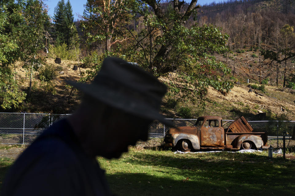 FILE - John Bain, a member of the Karuk tribe, walks by his 1954 Chevy five-window pickup that was destroyed in the Slater Fire, which tore through his property and the Klamath National Forest in Happy Camp, Calif., Oct. 6, 2021. The U.S. government has threatened to sue a unit of Warren Buffett’s Berkshire Hathaway to recover nearly $1 billion of costs related to the wildfires in 2020 in southern Oregon and northern California. The potential lawsuits were disclosed in an annual report filed by PacifiCorp’s parent company, Berkshire Hathaway Energy on Monday, Feb 26, 2024. (AP Photo/David Goldman, File)